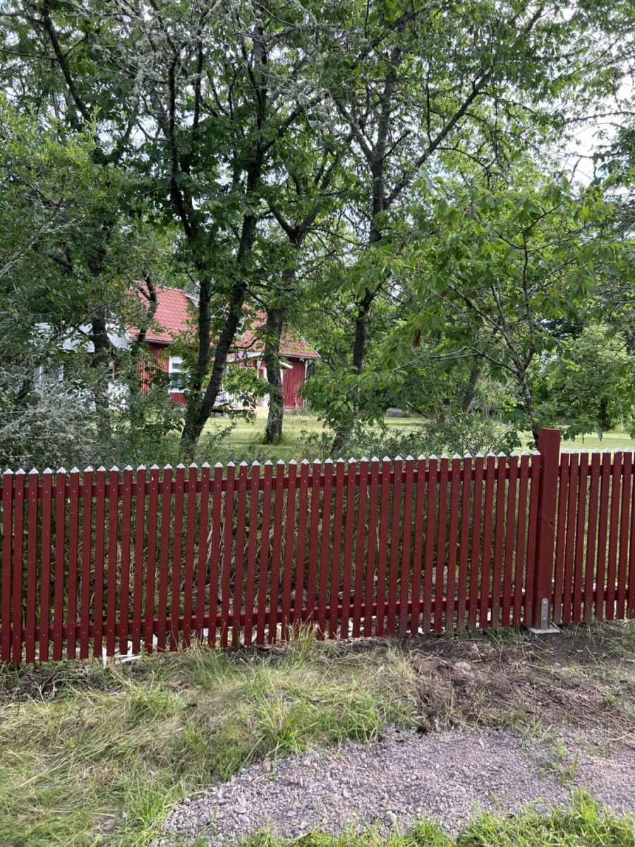 Staket byggt i bränt trä i röd färg.