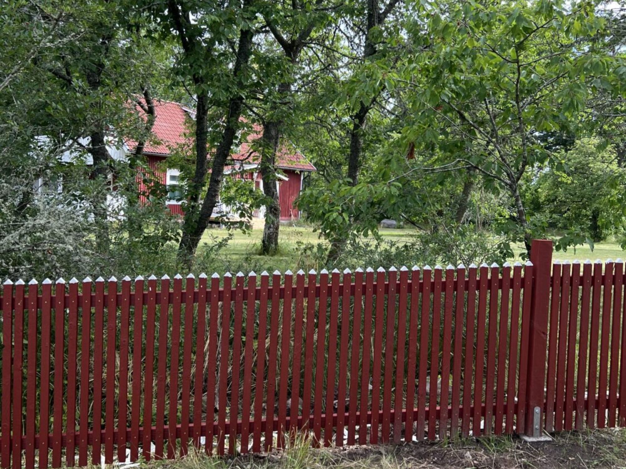 Staket byggt i bränt trä i röd färg.