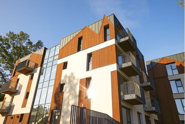 Lägenhetshus med fasad i bränt trä.
